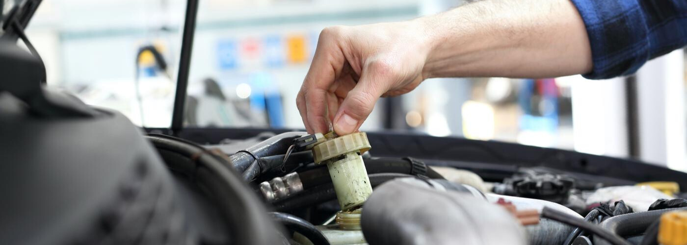 Mechanic checking brake fluid Mechanic checking brake fluid